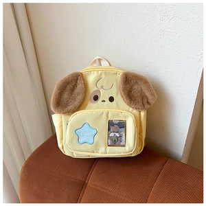 Close-up of yellow dog cartoon backpack with plush ears and star patch detail