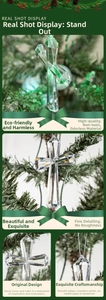 Detailed close-up of clear acrylic cross ornament with faceted edges on a Christmas tree