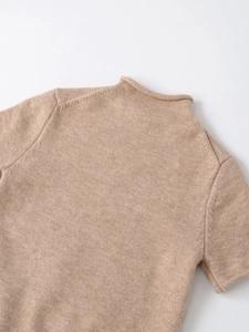 Close-up of the soft knit texture and mock neck detail of a beige short sleeve top