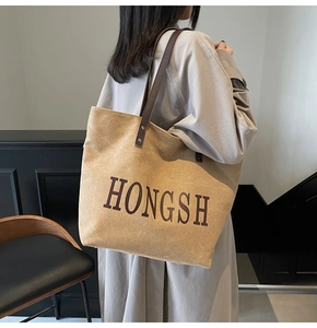 Detail view of large canvas tote bag showing the HONGSH print and brown leather handles