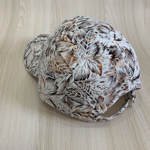 Détail de la casquette vintage à fleurs montrant la boucle métallique sur tissu texturé