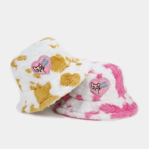 Detail of plush cow print bucket hats with pink heart cartoon cat embroidery