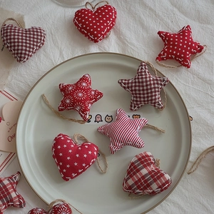 Detailed view of red and white fabric Christmas ornaments with hearts and stars patterns