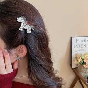 Detail of a sparkling crystal pony hair clip worn on wavy brown hair for a festive look