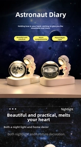 Close-up of 3D crystal ball night lights showing lunar and galaxy patterns with warm glow