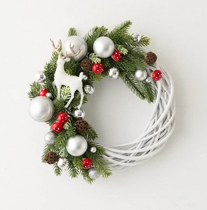 Detailed view of Christmas wreath featuring white base, green pine, and festive deer decor