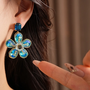 Gros plan de boucles d'oreilles vintage avec cristaux bleus et base en métal doré