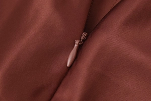 Detail of the high-quality invisible zipper on a maroon satin-textured lace skirt