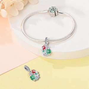 Dettaglio del bracciale in argento con ciondoli a forma di coccinella e quadrifoglio colorati