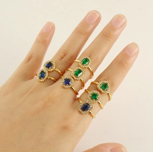 Detail of 18k gold plated adjustable rings featuring blue and green zircon gemstones