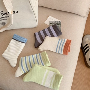 Vue détaillée de cinq paires de chaussettes en coton à rayures sur tissu beige