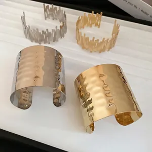 Minimalist irregular metallic cuff bracelets in gold and silver with textured ripple surface