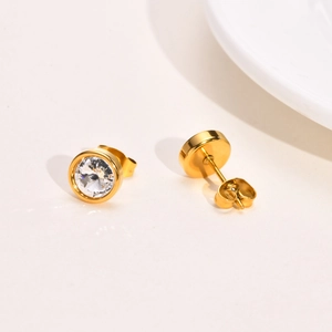 Close-up of gold titanium steel stud earrings with brilliant round-cut cubic zirconia