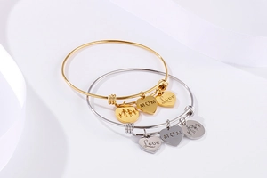 Detailed shot of two adjustable heart bangles with MOM and Love engraved charms