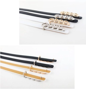 Close-up of slim women's belts with chain buckles in black, white, and camel faux leather