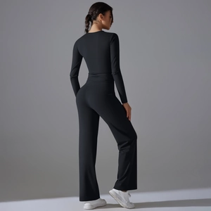 Détail du haut de yoga noir ajusté et du pantalon de sport à jambes larges assorti