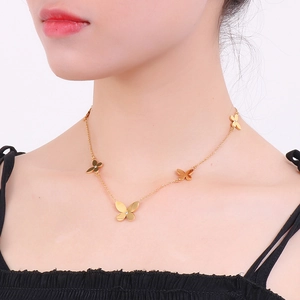 Detail of elegant gold butterfly necklace with zircon pendants on female model neck