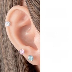 Detailed close-up of 5mm four-prong zircon stud earrings worn on the cartilage and lobe