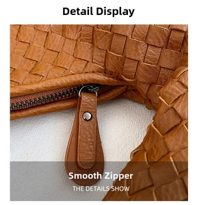 Macro shot of smooth zipper and intricate woven texture on the brown leather bag
