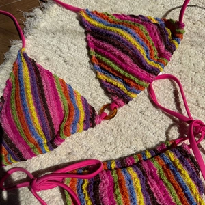 Détail d'un bikini en maille à rayures arc-en-ciel avec texture 3D et anneau central