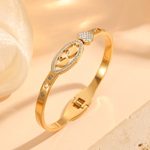 Gold plated titanium steel bangle featuring hollow swan and heart motifs with crystals