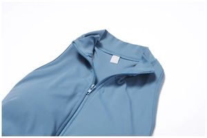 Détail du body de sport bleu poudré avec col montant zippé et texture lisse haute performance