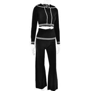 Detail of black knitted two-piece set with white stripes on hoodie and wide-leg pants