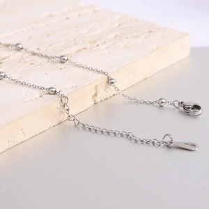 Minimalist stainless steel bead necklace with lobster clasp and adjustable chain on stone