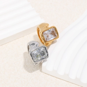 Detailed shot of gold and silver textured rings featuring large square-cut gemstones
