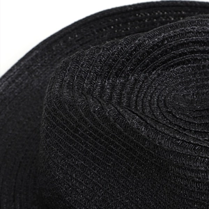 Dettaglio macro del cappello da cowboy in paglia nera che mostra la trama intrecciata