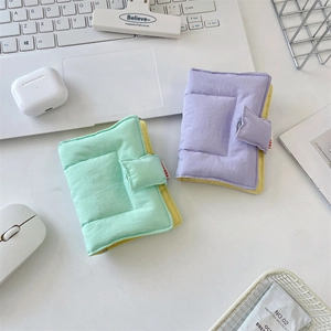 Close-up of padded fabric notebook covers in mint green and lilac with magnetic closure