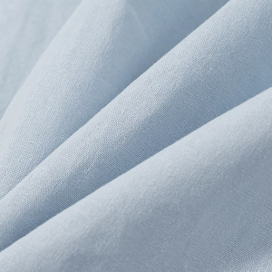 Close-up of light blue linen-blend fabric showing detailed plain weave texture