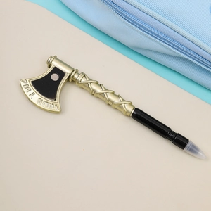 Detail shot of a creative axe-shaped ballpoint pen in gold and black with clear protective cap