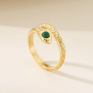Détail d'une bague serpent avec pierre verte et écailles texturées dorées