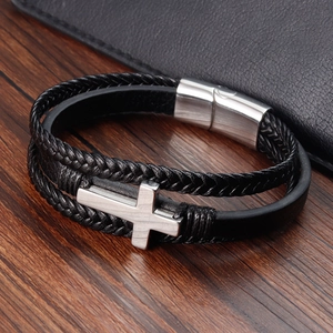 Close-up of black braided leather bracelet with silver cross and magnetic metal clasp