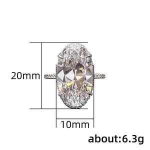 Silver oval cut zircon ring with four-prong setting and pavé side stones on white background