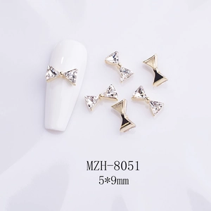 Detail of 5x9mm gold bowknot nail art charms with K9 rhinestones and sizing scale