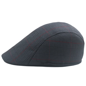 Detail of dark grey plaid flat cap showing red check pattern and wool-like texture