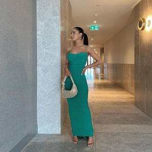 Detailed view of emerald green backless maxi dress with side ruching and glossy finish