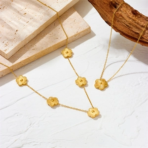 Golden stainless steel five-petal clover jewelry set featuring elegant necklaces and earrings