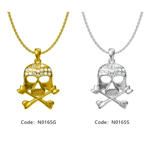 Vue détaillée des pendentifs tête de mort en or et argent avec pierres de zircon blanc