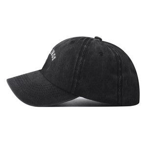 Close-up of INGS embroidery on a vintage washed black cotton baseball cap with detail texture