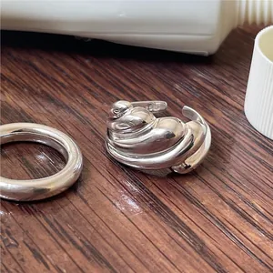 Close-up of polished silver spiral ring with industrial minimalist design on wood table