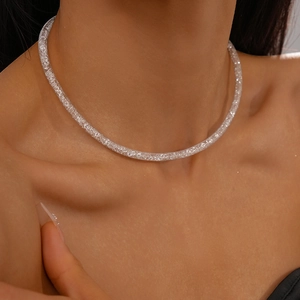 Close-up of silver zircon tubular mesh necklace worn by a model on the collarbone