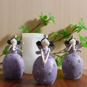 Three purple garden fairy resin figurines with silver wings on a rustic wooden base