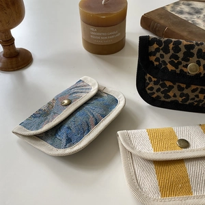Three mini canvas pouches in floral, leopard, and striped designs with metal snap buttons