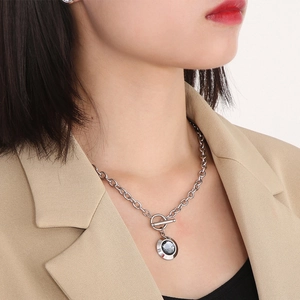 Close-up of a stainless steel OT clasp necklace with a dark faceted crystal pendant