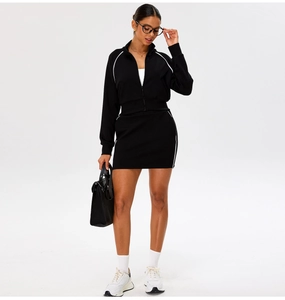 Detail of black sports set featuring zipper jacket and mini skirt with white stripes
