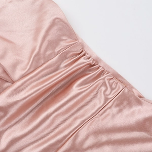 Detailed macro view of pink satin fabric with elegant pleated texture and silk gloss finish
