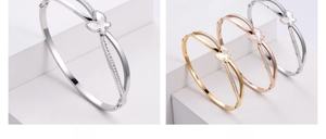 Detail of butterfly bangles in gold, rose gold and silver with zircon and shell inlay